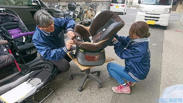 ベビーカー本体からシートを外す小林社長(左)