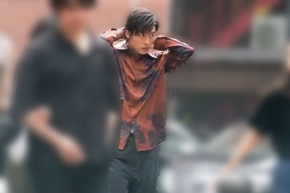  ネックレスをつけながら歩く目黒（写真：本誌写真部） 