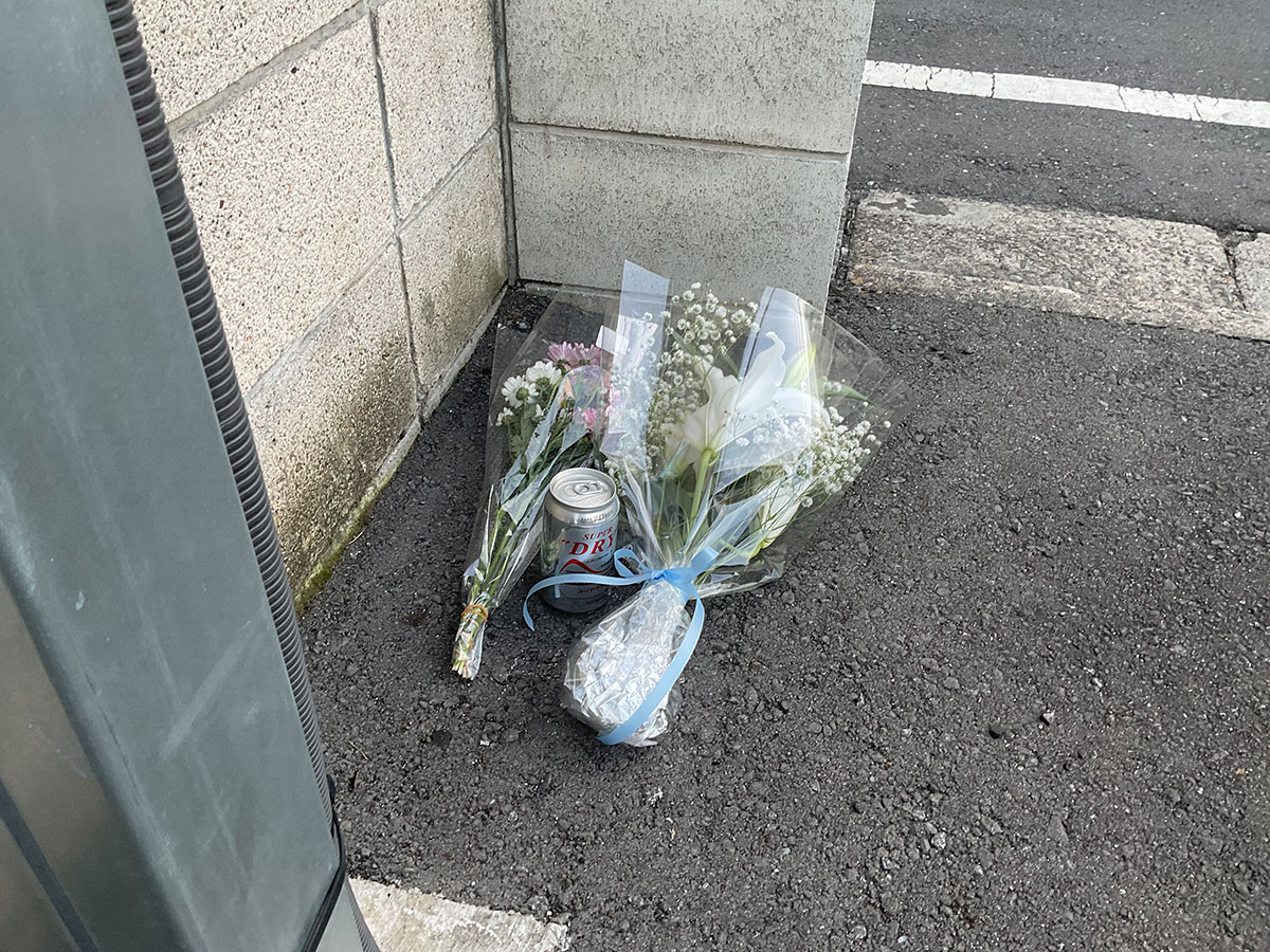 アパートのそばには花束と缶ビールが置かれていた
