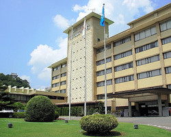 名鉄犬山ホテルの外観。左手奥に犬山城が見える=名古屋鉄道提供