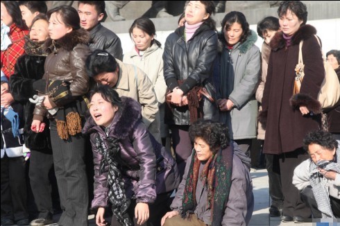 2011年、金正日氏の銅像前で彼の死去を悲しむ北朝鮮の人々（朝鮮中央テレビ）