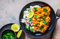 Vegetarian lentil stew with rice in a black plate. Healthy vegan food concept.