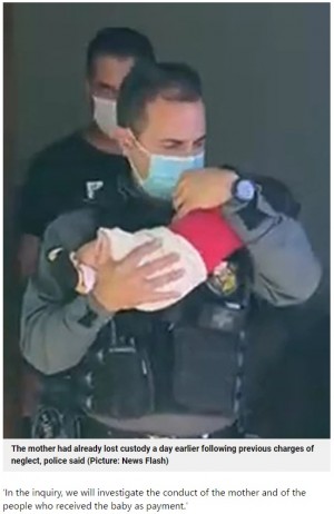 警察官に保護される男児(画像は『Metro 2021年6月12日付「Mum ‘uses two-month-old baby as guarantee on her drug debts’」(Picture: News Flash)』のスクリーンショット)