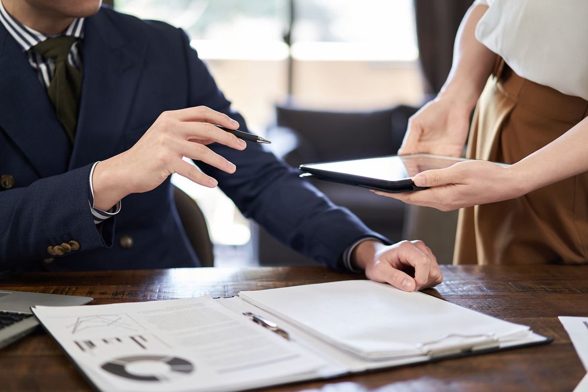 タブレット端末を差し出す女性に支持を出す男性