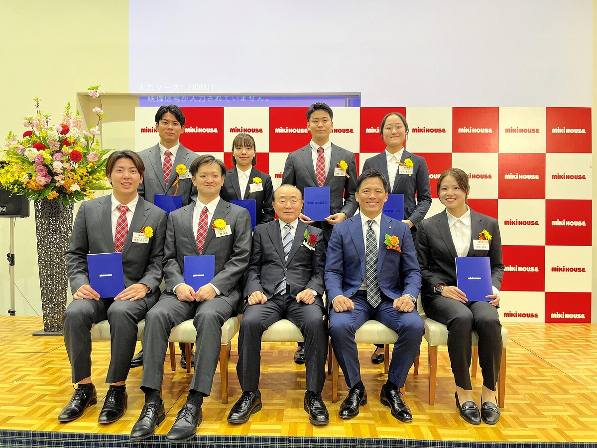 入社式で笑顔の池本凪沙(前列右)と木村皓一社長(前列中央)と野村忠宏同社スポーツクラブGM(同右から2人目)