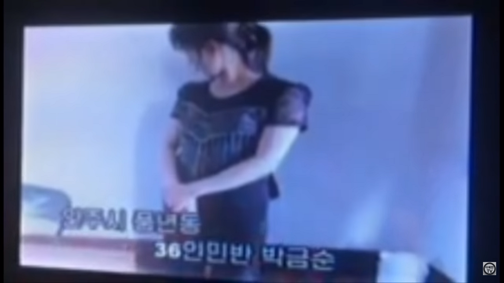 服装チェックに引っかかり連行され、カメラの前に立たされた若い女性(北朝鮮の幹部向け映像キャプチャ)