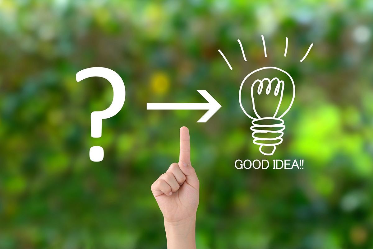 自然な緑色の背景にケシトンマークと電球の照明を指す子供の手