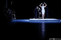 「コペルニ」23年春夏コレクションで、スプレーでドレスの素材を吹き付けられるモデルのベラ・ハディッド。パリ・ファッションウィークで（2022年9月30日撮影）。(c)JULIEN DE ROSA / AFP