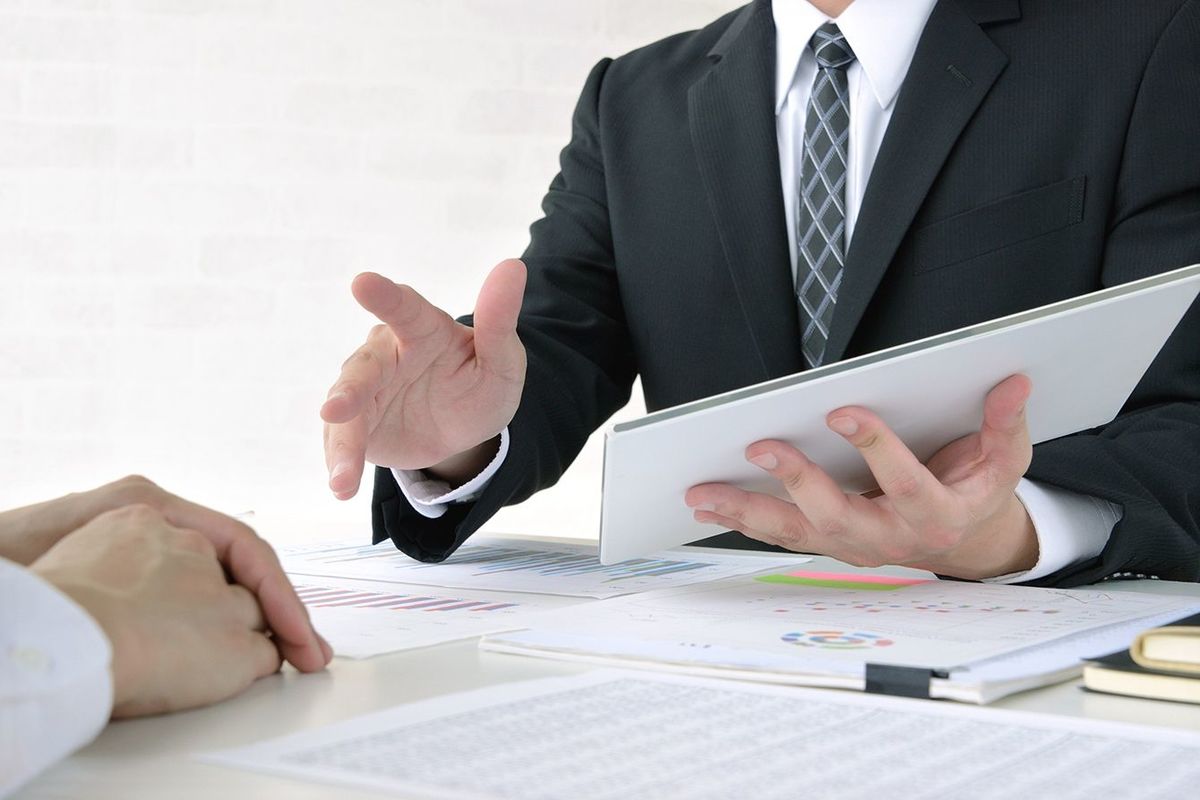 タブレットを見せて説明するアジアのビジネスマン