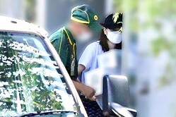  10月初旬、帽子を目深に被り変装しながら荷物を受け取る片瀬 