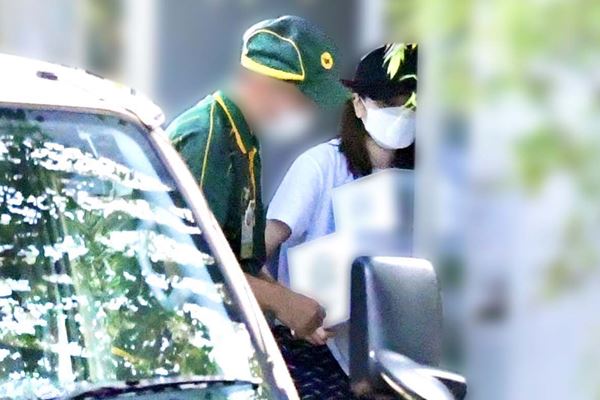  10月初旬、帽子を目深に被り変装しながら荷物を受け取る片瀬 
