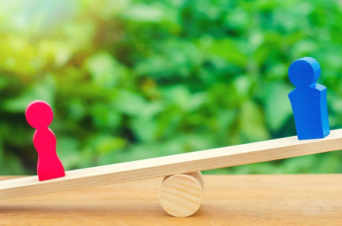 男女のフィギュアが載っているシーソー