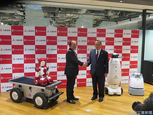 清掃や警備、運搬ロボなどを大学キャンパス内で実証する(吉田淳一三菱地所社長(右))